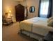 A primary bedroom has a patterned chair, carpet, and large armoire at 306 Park St, Saint George, SC 29477