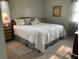 This bedroom features natural light from the window, wood furniture, decorative pillows, and a patterned white quilt at 306 Park St, Saint George, SC 29477