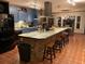 A spacious kitchen showcases a brick island with seating, modern appliances, ample lighting, and tile flooring at 306 Park St, Saint George, SC 29477