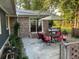 Outdoor patio area features a dining set with red cushions, umbrella, grill, and beautiful landscaping at 306 Park St, Saint George, SC 29477