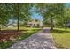 Long driveway leading to a two-story home with mature trees and manicured lawn at 309 Pinopolis Park Dr, Moncks Corner, SC 29461