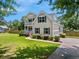 View of the home's exterior with a well-maintained lawn and a paved driveway at 309 Pinopolis Park Dr, Moncks Corner, SC 29461
