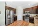 Well-lit kitchen featuring stainless steel appliances, dark wood cabinetry, and granite countertops at 309 Pinopolis Park Dr, Moncks Corner, SC 29461