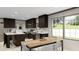 Well-lit kitchen featuring dark cabinetry, a center island, modern appliances, and an adjacent dining area at 313 Marion Rd, Dorchester, SC 29437