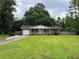 A well-maintained lawn, a driveway and landscaping complement this red brick home's classic curb appeal at 352 Oxford Rd, Ladson, SC 29456