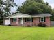 Charming one-story red brick home with a well-manicured lawn, a light blue door and black shutters at 352 Oxford Rd, Ladson, SC 29456