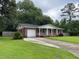 Inviting front yard with a lush lawn and a long driveway leading to an attached garage at 352 Oxford Rd, Ladson, SC 29456