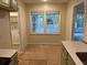 Bright kitchen area with a window, wooden floors, and a view to the sunroom at 352 Oxford Rd, Ladson, SC 29456