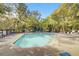 Large community pool surrounded by lounge chairs and lush trees at 3903 Poplar Grove Pl, Summerville, SC 29483