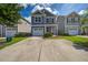 Charming two-story home with a well-manicured lawn, long driveway, and an attached garage at 3903 Poplar Grove Pl, Summerville, SC 29483