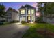 Charming two-story home illuminated at dusk, featuring a well-manicured lawn and driveway at 3903 Poplar Grove Pl, Summerville, SC 29483