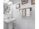 Elegant half-bathroom featuring a pedestal sink, decorative towels, and tasteful artwork at 412 Grand Palm Ln, Summerville, SC 29485