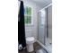 Modern bathroom with a glass-enclosed shower, wood-look flooring, and a window with views of mature trees at 412 Grand Palm Ln, Summerville, SC 29485