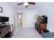 Carpeted bedroom with ceiling fan, TV on display stand, and doorway views to an adjacent bathroom at 412 Grand Palm Ln, Summerville, SC 29485