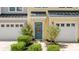 Inviting yellow townhome entrance with a blue door, complemented by decorative shrubbery and a seasonal wreath at 412 Grand Palm Ln, Summerville, SC 29485