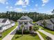 A high angle aerial view of a gray home with mature landscaping, neighboring homes, and a tree-lined backdrop at 4140 Home Town Ln, Ravenel, SC 29470