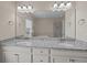A bathroom with a double sink vanity, granite countertops, and a large mirror at 4140 Home Town Ln, Ravenel, SC 29470