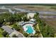 Aerial view of a community pool featuring a cabana, lounge chairs, lush landscaping, and a view of the adjacent marsh at 4140 Home Town Ln, Ravenel, SC 29470