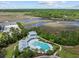 Aerial view of a community pool featuring a cabana, lounge chairs, lush landscaping, and a view of the river at 4140 Home Town Ln, Ravenel, SC 29470