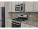 A modern kitchen showcasing stainless steel appliances, granite countertops, and stylish backsplash at 4140 Home Town Ln, Ravenel, SC 29470