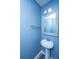 Charming half-bathroom featuring a pedestal sink, a decorative mirror, a brushed nickel towel bar, and light blue walls at 431 Buckhannon Ln, Moncks Corner, SC 29461
