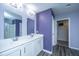 Full bathroom with double sinks, white cabinets, shower with glass door and purple walls at 431 Buckhannon Ln, Moncks Corner, SC 29461