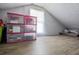 Finished attic space features wood-look flooring, a window, and ample room for storage in bins at 439 Temple Rd, Ladson, SC 29456