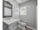 Elegant bathroom features a classic pedestal sink, ornate mirror, and neutral color scheme at 439 Temple Rd, Ladson, SC 29456