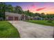 Sunset view of home featuring a long driveway, mature trees, and well-maintained lawn at 439 Temple Rd, Ladson, SC 29456