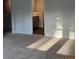 Neutral bedroom space with soft carpeting, natural light, and convenient access to a nearby bathroom at 4669 Palm View Cir, North Charleston, SC 29418