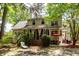 Large backyard featuring the home, screened porch, patio, and mature trees at 477 Commonwealth Rd, Mount Pleasant, SC 29466