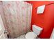 Bathroom with a toilet, shower, and a red accent wall at 477 Commonwealth Rd, Mount Pleasant, SC 29466