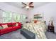 Bright bedroom with a red couch, and plenty of natural light from the large windows at 477 Commonwealth Rd, Mount Pleasant, SC 29466