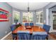 Dining area featuring a wood table, comfortable blue chairs, and natural light from the bay windows at 477 Commonwealth Rd, Mount Pleasant, SC 29466