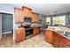 Well-lit kitchen with stainless steel appliances and warm wood cabinetry, seamlessly flowing into dining area at 477 Commonwealth Rd, Mount Pleasant, SC 29466