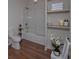 Clean bathroom with a shower-tub combo, wooden shelves, white tiling, and modern fixtures at 480 Longleaf Dr, Walterboro, SC 29488
