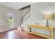Inviting foyer featuring hardwood floors, staircase, and a stylish yellow console table at 492 Sanders Farm Ln, Wando, SC 29492