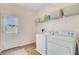 Well-organized laundry room with washer, dryer, wire shelving, and access to backyard at 492 Sanders Farm Ln, Wando, SC 29492