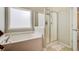 Bright main bathroom features a glass enclosed shower, separate tub, and tile floors at 492 Sanders Farm Ln, Wando, SC 29492