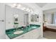 Bathroom featuring double sinks, green marble countertops, and neutral decor at 505 E Arctic Ave, Folly Beach, SC 29439