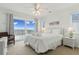 Bright bedroom featuring a queen bed, a ceiling fan, and sliding glass doors to a beachfront balcony at 505 E Arctic Ave, Folly Beach, SC 29439
