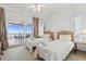Bright bedroom featuring two twin beds, a ceiling fan, and sliding glass doors to a beachfront balcony at 505 E Arctic Ave, Folly Beach, SC 29439