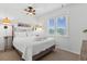 Cozy bedroom with a full bed, a ceiling fan, a window with blinds, and beach-themed wall art at 505 E Arctic Ave, Folly Beach, SC 29439