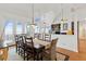 Elegant dining room with a large table, chairs, chandelier, and direct access to the porch with ocean views at 505 E Arctic Ave, Folly Beach, SC 29439