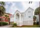 Charming beach house with white siding, arched porch, lattice foundation, and lush palm trees at 505 E Arctic Ave, Folly Beach, SC 29439