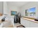 Bright laundry room with built-in cabinets, modern washer and dryer, and a window overlooking the outdoors at 505 E Arctic Ave, Folly Beach, SC 29439