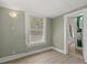 A light-filled bedroom with a window, light-green walls, neutral flooring, and white trim at 509 E Ashley Ave, Folly Beach, SC 29439