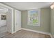 A compact bedroom featuring light-green walls, a window, neutral flooring, and white trim at 509 E Ashley Ave, Folly Beach, SC 29439