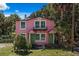 Charming pink two-story home with a balcony, surrounded by lush landscaping at 509 E Ashley Ave, Folly Beach, SC 29439