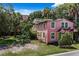 A charming pink two-story home, surrounded by a lush, green yard and various trees at 509 E Ashley Ave, Folly Beach, SC 29439